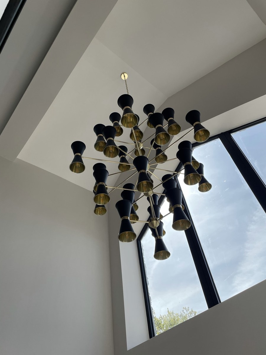 Black and gold sputnik chandelier under a pitched window