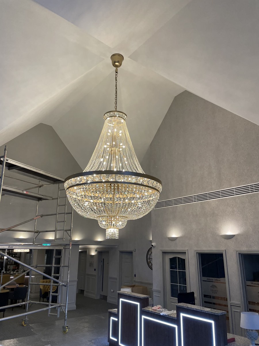 Large crystal chandelier installed in a vaulted reception