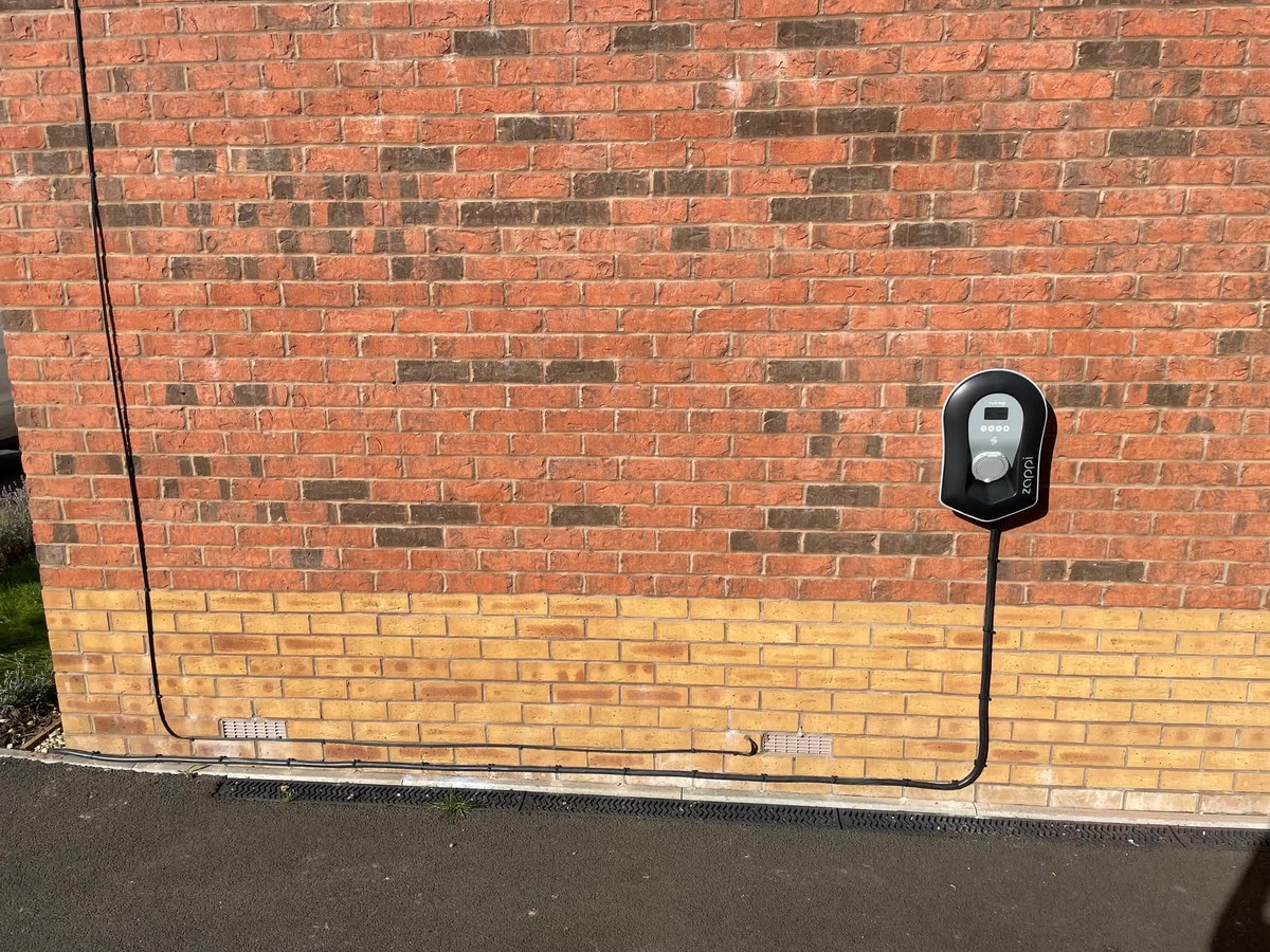EV charger mounted on a brick house wall