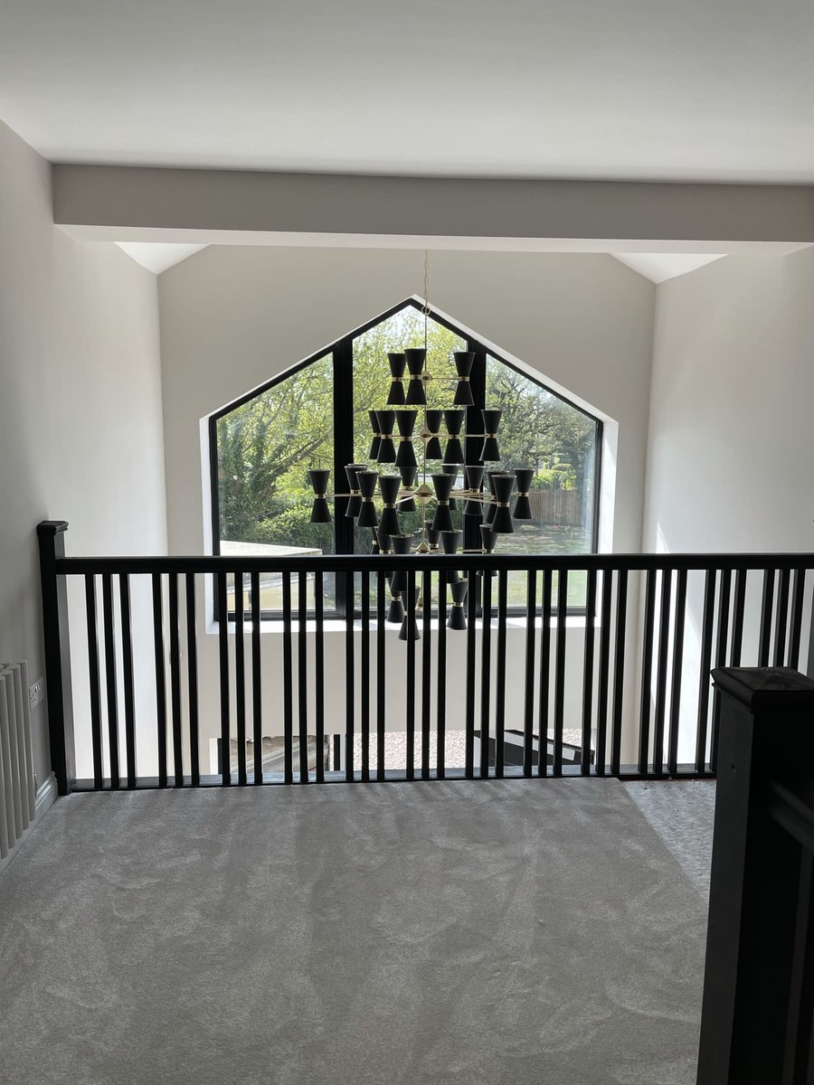 Modern black and brass chandelier on a galleried landing